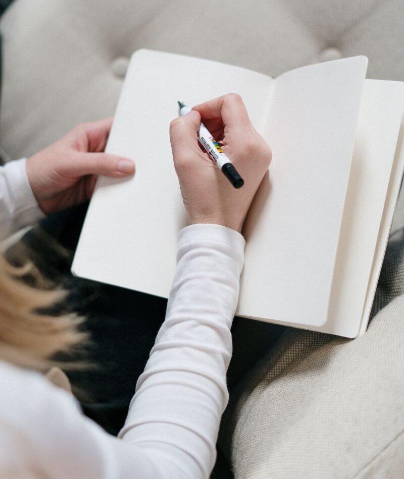 Human Design Angebot – Mandy Egerland Hand schreibt in ein offenes Notizbuch – Symbol für Reflexion und Klarheit im Human Design